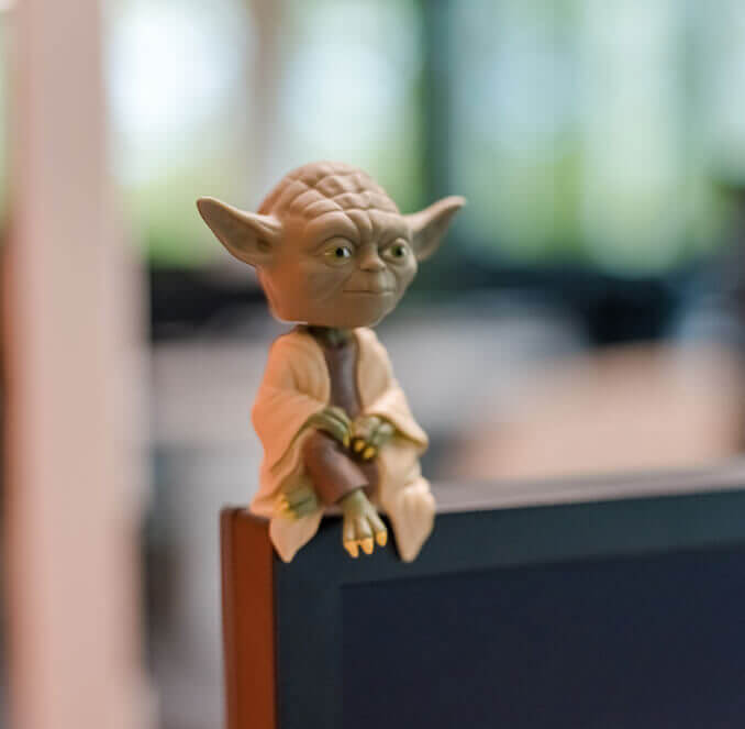 Yoda-Figur, die auf einem Bildschirm sitzt.